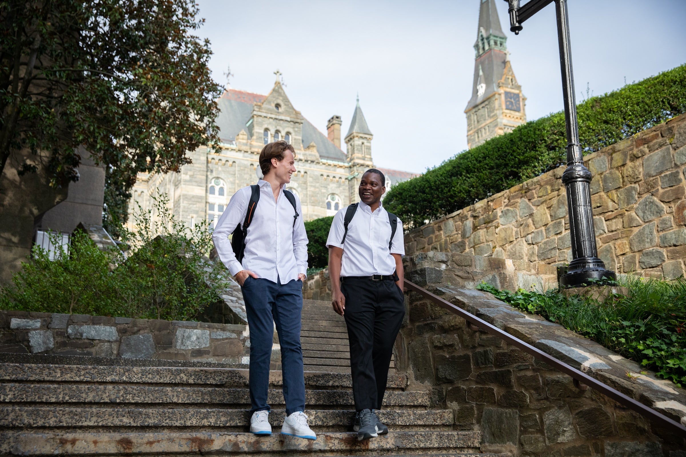 Two students walking together down stairs outside at Georgetown.