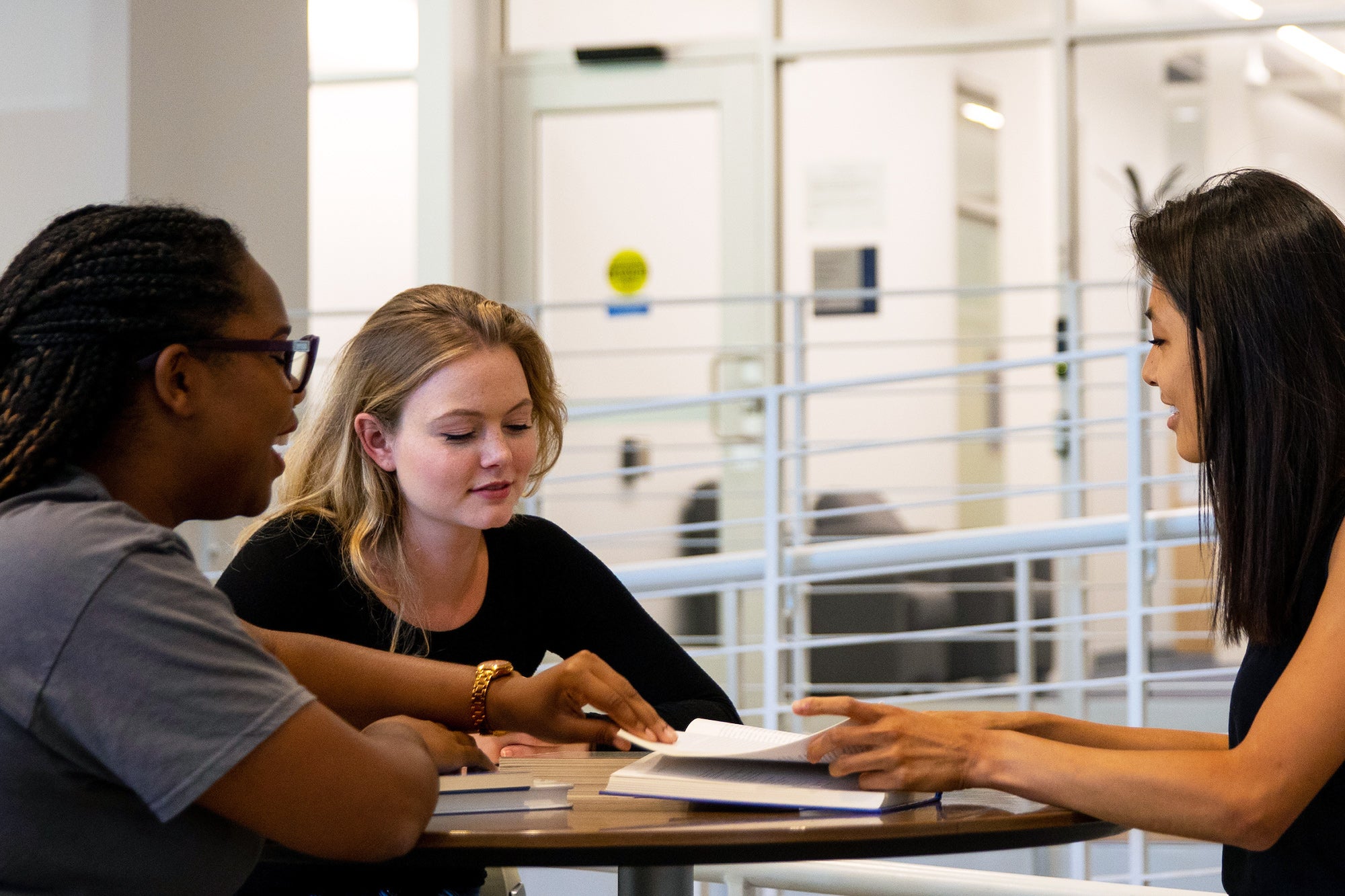 Three students sitting around a table in a discussion