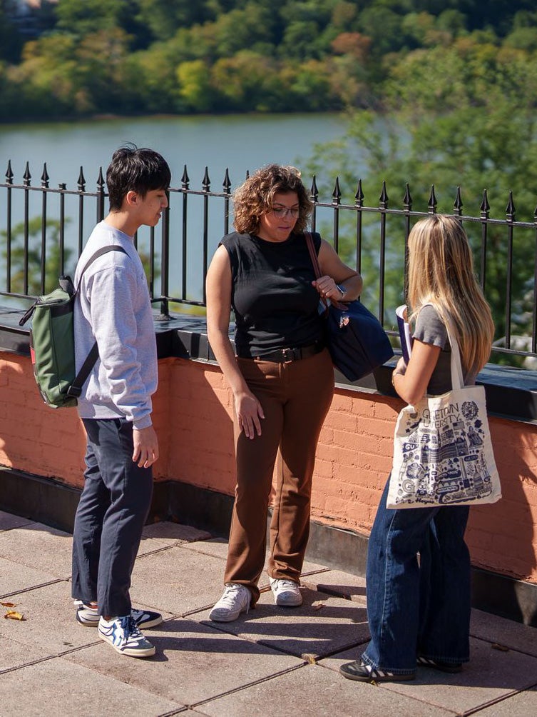 Three students standing together outside of the Car Barn.