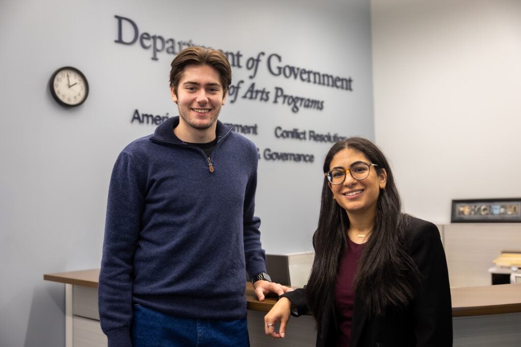 Antoine and May posing together in front of the Department of Government sign.